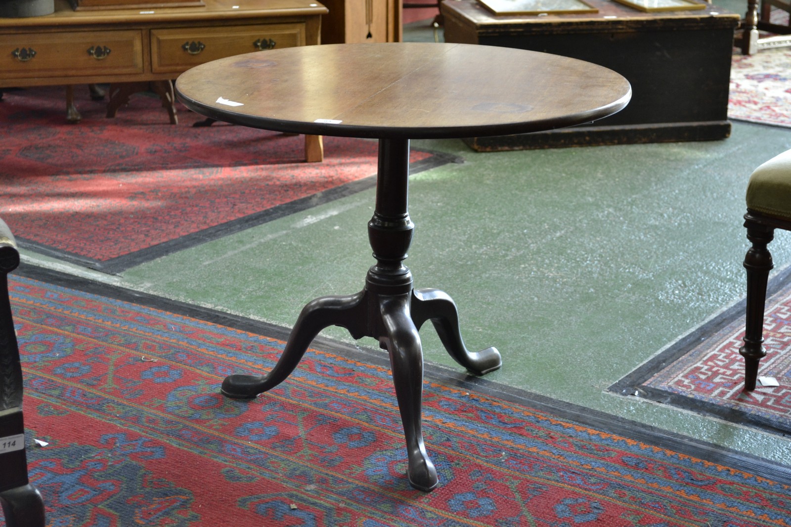 A George III mahogany occasional table, the circular top tilting on turned column, tripod legs,