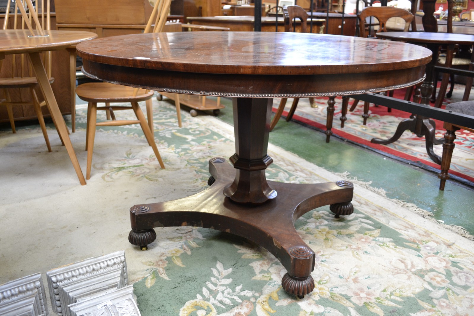 A George IV mahogany centre table, circular tilting top, panelled column with lotus socle,