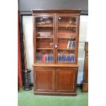 A Victorian mahogany bookcase cabinet, moulded cornice, glazed doors to top, projecting base,