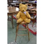 A pine breakfast bar chair and a Teddy bear.