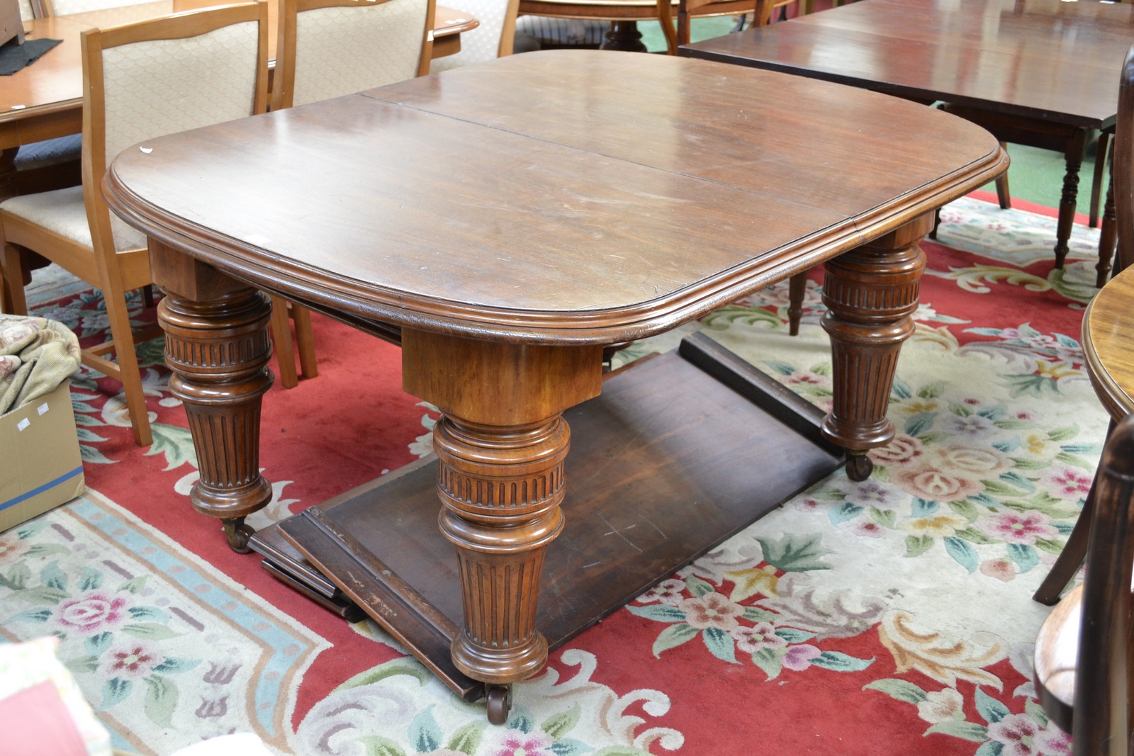 A large Victorian mahogany wind-out dining table, three leaves, bold fluted and turned legs,