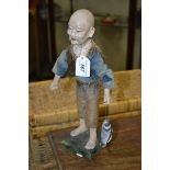 A Chinese composition figure, of a fisherman, he stands, holding his catch, 36cm high,