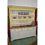 A large pine dresser, outswept cornice, dentil frieze, three shelves to top,