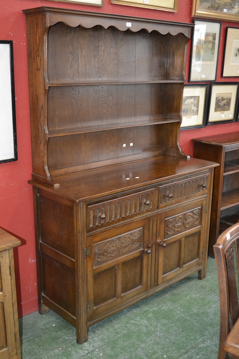 A Priory style oak dresser, stepped cornice, shaped uprights, two shelves to top,