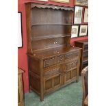 A Priory style oak dresser, stepped cornice, shaped uprights, two shelves to top,