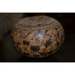 A Bolivian folk art carved nut, the surface extensively worked illustrating scenes of daily life, c.