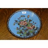 An early 20th century Chinese cloisonne charger decorated with butterflies and flowers on a blue
