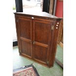 A George III oak splay front corner cabinet,  the moulded dentil cornice,