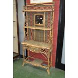A bamboo and wicker hall stand with an arrangement of shelving, drawer and mirror.