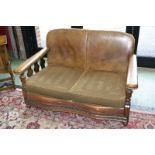 A 1930's oak and leather two seat sofa, padded leather back and arms, squab cushions,
