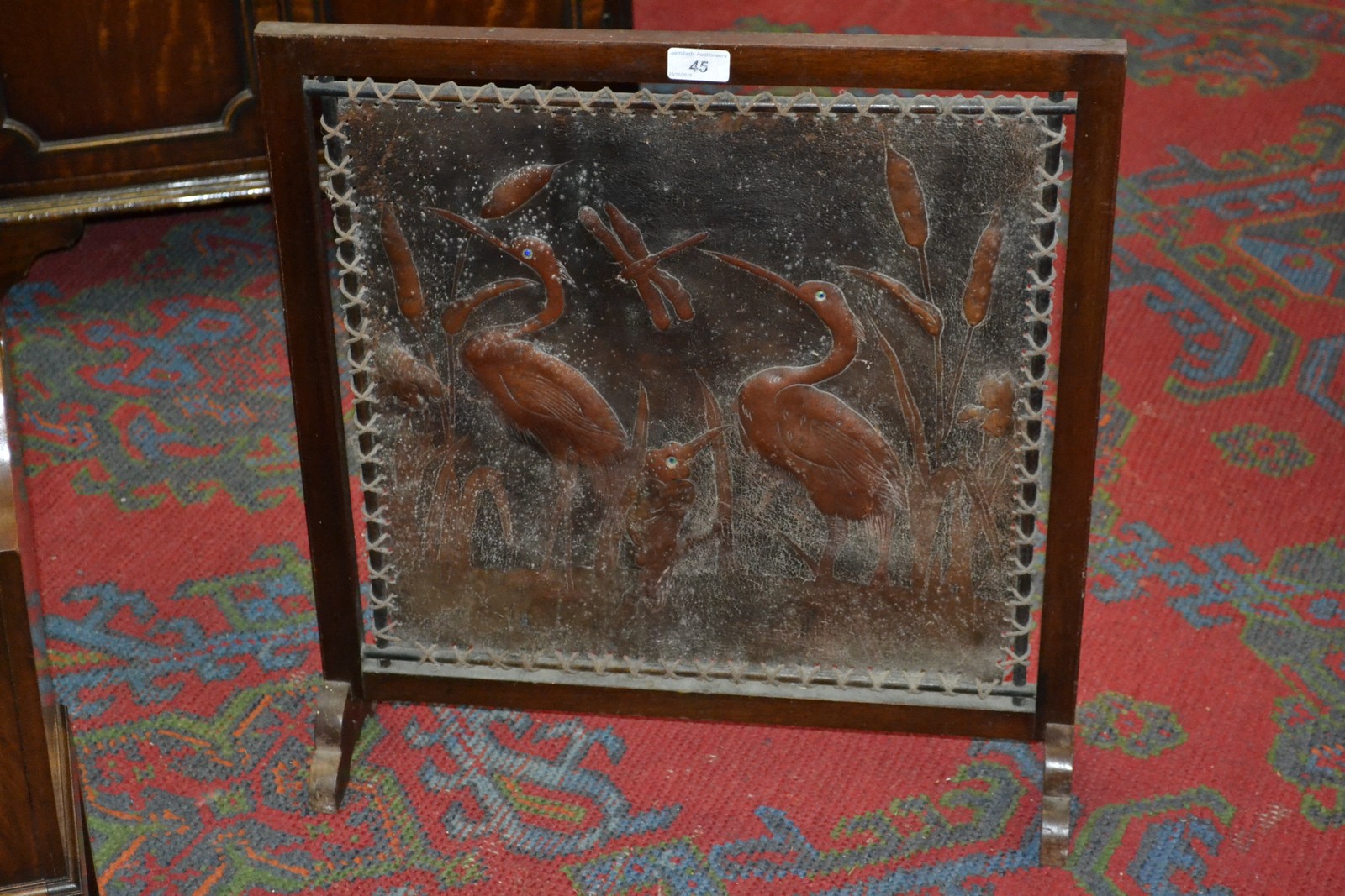 An Art Nouveau mahogany and tooled leather fire screen,