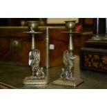 A pair of 19th century bronze mantel sticks, cast with griffins, campana sconces, dished drip pans,