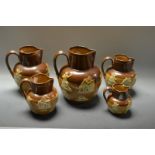 A graduated set of five salt glazed jugs,