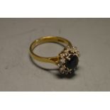 A sapphire and diamond cluster ring, central oval deep blue sapphire, approx 1.