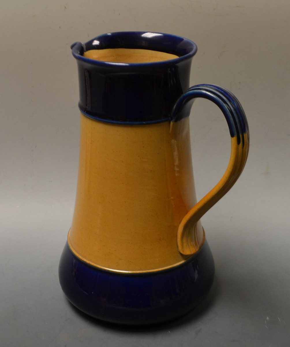 An early 20th century Royal Doulton earthenware water jug, plain and blue banded body,