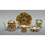 A Royal Crown Derby miniature 1128 Imari tea pot; a milk jug and conforming oval box and cover;