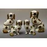 A pair of Victorian Staffordshire spaniels, 24cm high; another pair, smaller,