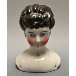 A Continental pottery shoulder doll head, painted black hair, blue eyes, c.