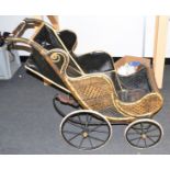 A Victorian wicker four wheel push chair, black and yellow woven body, metal sprung coil suspension,