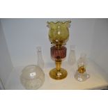 An early 20th century oil lamp, amethyst  glass reservoir,