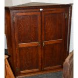 A George III oak splay front corner cabinet,  the moulded dentil cornice,