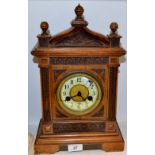 A late 19th century walnut mantel clock, Arabic numerals, twin winding holes, striking on a gong, c.