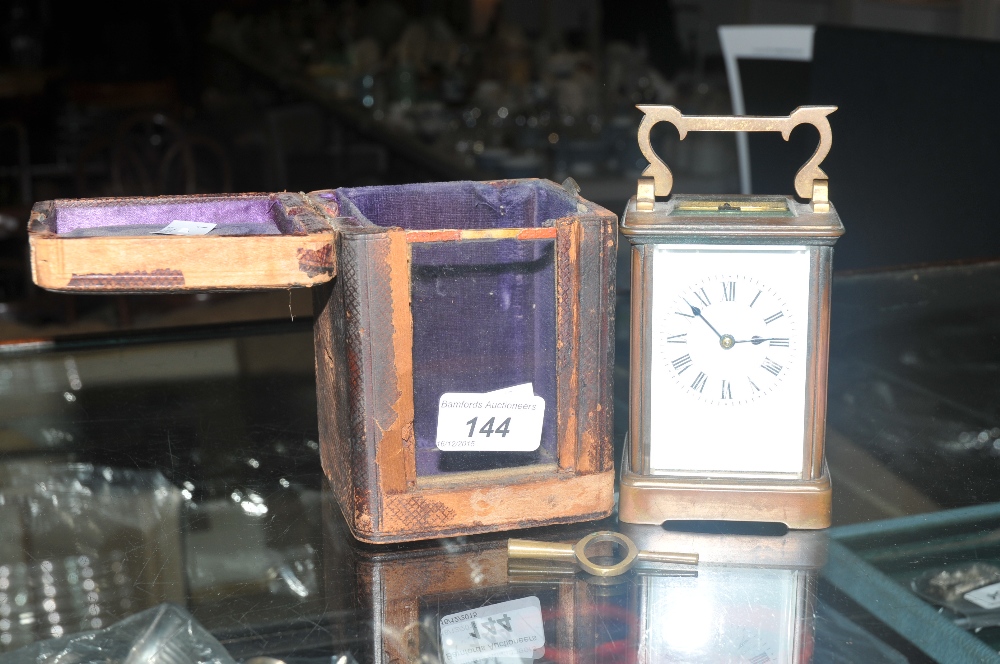 A brass Art Deco carriage clock, white enamel dial; Roman numerals,