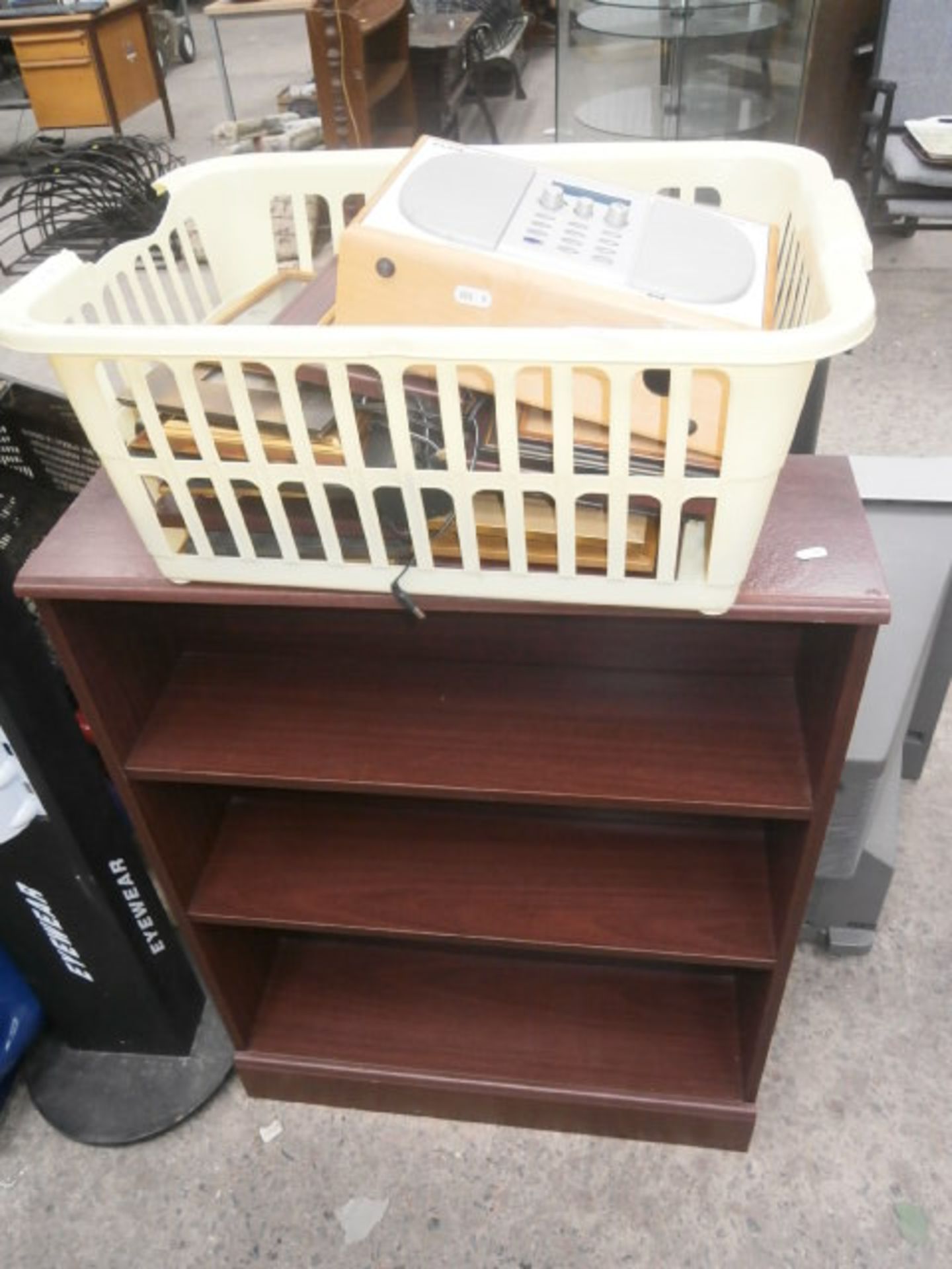 Small bookcase and a basket containing digital radio and picture frames