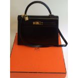 A mint condition vintage Hermés Black Veau box calf leather gold HD Kelly hand bag. The handle has a