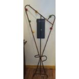 A 1960’s/70’s black tubular shaped coat rack/stick stand with central mirror and carved wooden