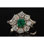 An emerald and diamond mounted circular