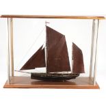 A cased model of a fishing boat PH42:, fully rigged with over painted metal sails,