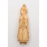 A marine ivory carved figure of a Polynesian woman:, in traditional costume, 10cm high.