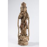 A Chinese carved wood figure of Kuan-Yin: in flowing robes, standing on a lotus flower,