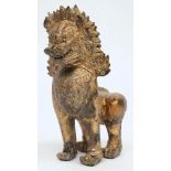 A Far Eastern  gilded bronze temple lion: of traditional design, standing on all fours,