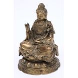 A Chinese bronze figure of Buddha: wearing traditional robes, seated cross legged on a lotus flower,