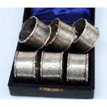 A cased set of six Edward VII silver napkin rings, maker Williams Limited, Birmingham 1901,