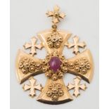 A cruciform pendant with central oval, cabochon ruby:, approximately 17gms gross weight.