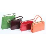 A green 'snake skin' hand bag together with various red, orange and purple hand bags:.