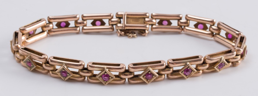 A 9ct gold and ruby-set gate-link bracelet:, each link with a single, circular ruby.