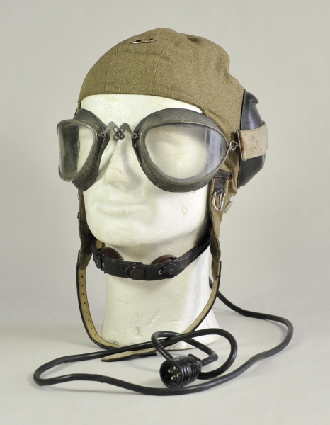 Fliegerhaube mit Kehlkopfmikrophon.Haube mit Verkabelug und Fliegerbrille.Zustand: II

Flying cap