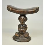 7.2.) EthnologicaKopfstütze mit Karyatidenfigur, Luba (D. R. Kongo)Höhe 17 cm. Auf flachem Kegel