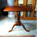 A George III mahogany tripod library reading table, the rectangular top with detachable rest, hinged