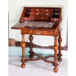 A William and Mary figured walnut writing desk, feathered and crossbanded top, similar slope,