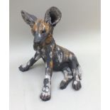 Nick Mackman A Raku-fired pottery sculpture of " Wild Dog Pup", seated, ears pricked, partial glazed