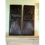 A pair of carved oak furniture panels, one of a full length figure of a woman standing in a long