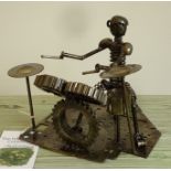 A 20th century sculpture of a drummer, made using reclaimed automotive parts, i.e. cogs, springs