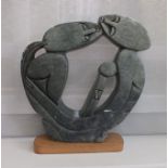 A carved soapstone free standing figural group of an embracing couple, supported on plain plinth