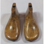 A pair of late 19th century child's shoe lasts, size 4, carved wood with metal plate soles, 14cm