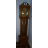 A modern oak finished longcase clock, with brass dial and silvered chapter ring, bearing the